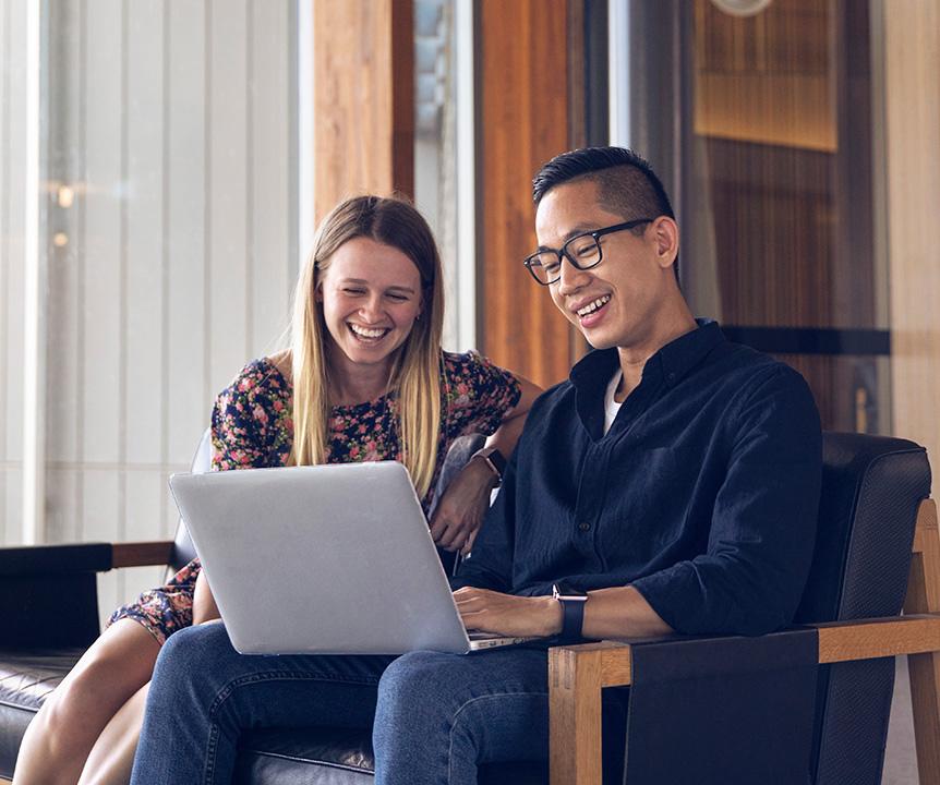 two people looking at laptop while sitting